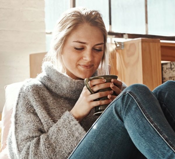 Person enjoying a cozy indoor atmosphere, illustrating the comfort of efficient heating systems and thermostat control.